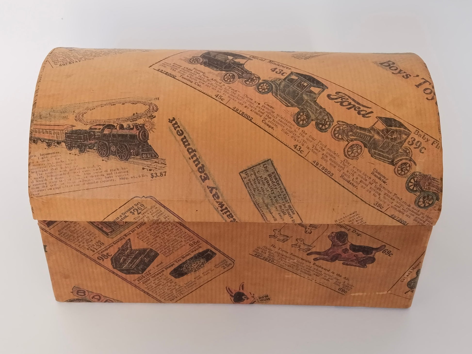 Vintage Schminkkästchen in Truhenform, geschlossen von vorne, Karton mit nostalgischem Spielzeugkatalog-Druck

