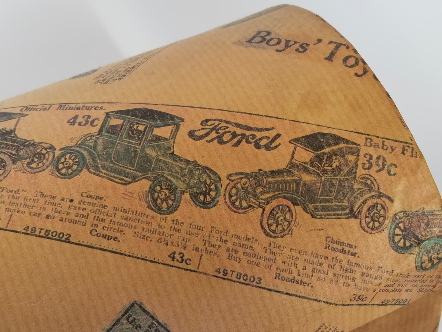Nahaufnahme des gewölbten Deckels mit Ford-Modellauto-Annoncen und Schriftzug Boys Toys
