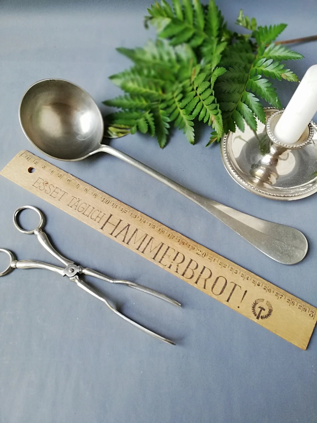 Ansicht der Vintage-Servierkelle aus den 1940er Jahren mit langem Griff mit lLineal, Kerzenständer und Tortenheber.