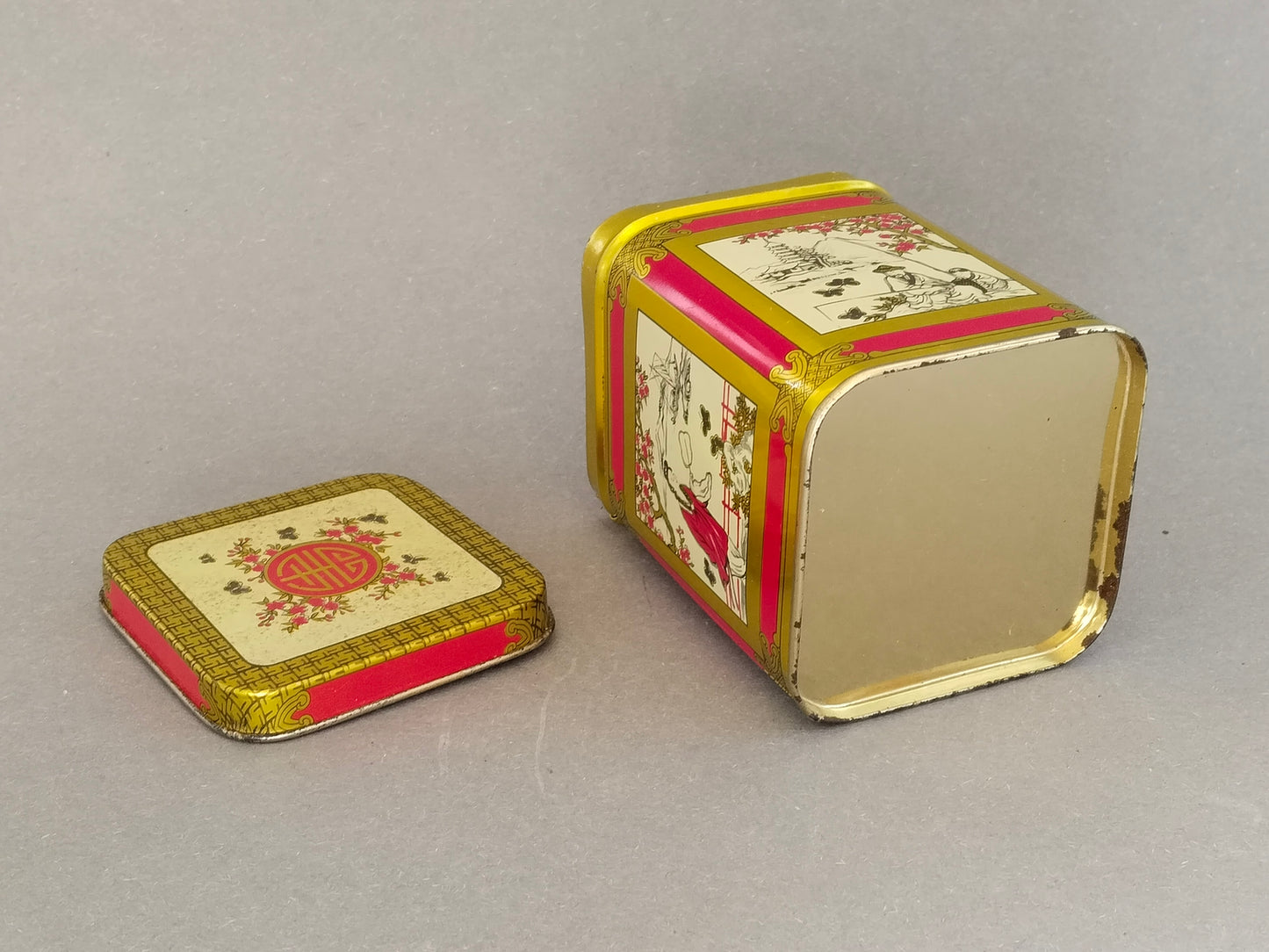 Unterseite der Vintage-Teedose: blanker goldfarbener Boden ohne Herstellermarke, Deckel daneben