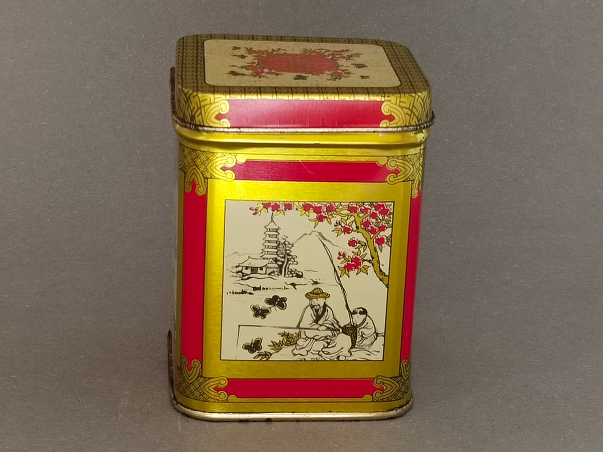 Vintage Teedose schräg von vorne, goldener Zierrahmen und rote Felder um die Anglerszene
