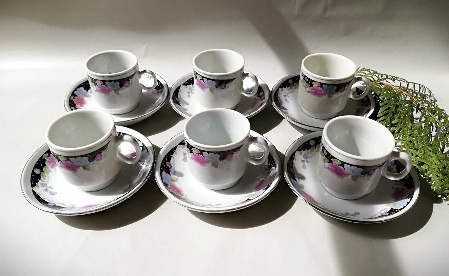 Sechsteiliges chinesisches Porzellan-Set mit bunten Blumenmotiven auf weißem Grund.