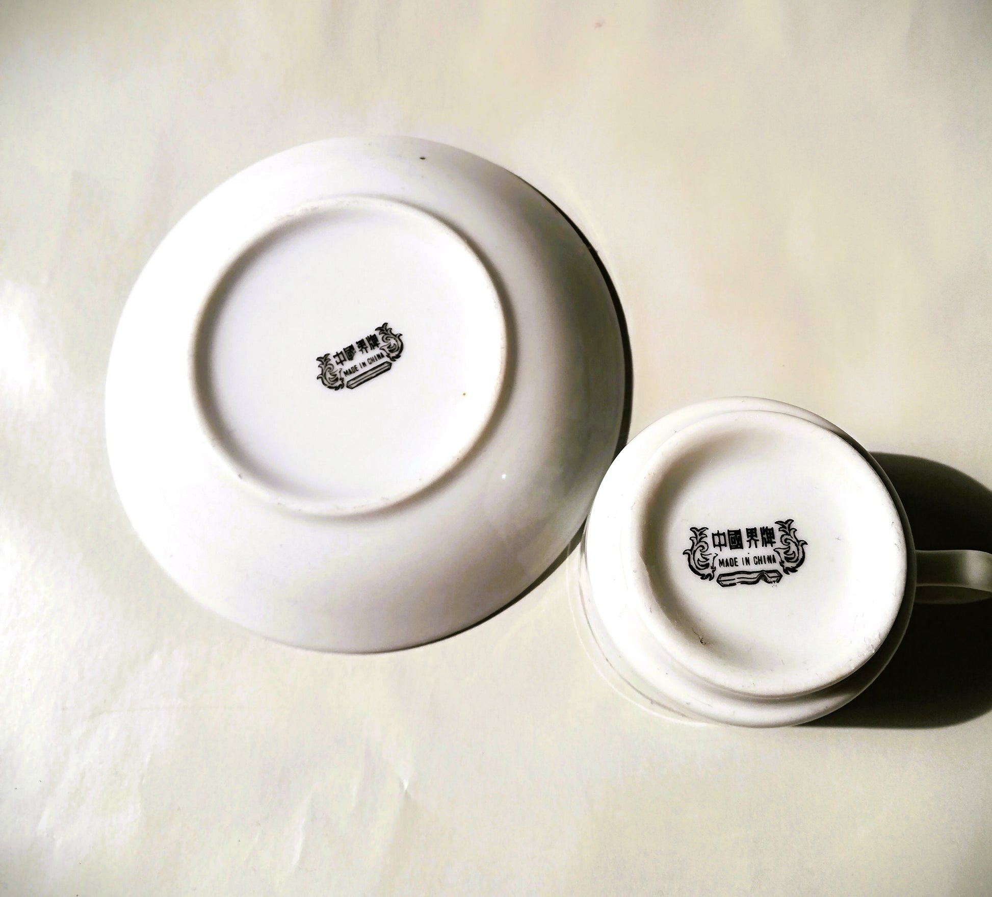 Sechsteiliges chinesisches Porzellan-Set mit bunten Blumenmotiven auf weißem Grund. Tasse und Teller nach oben mit ichtbarer Stampe.