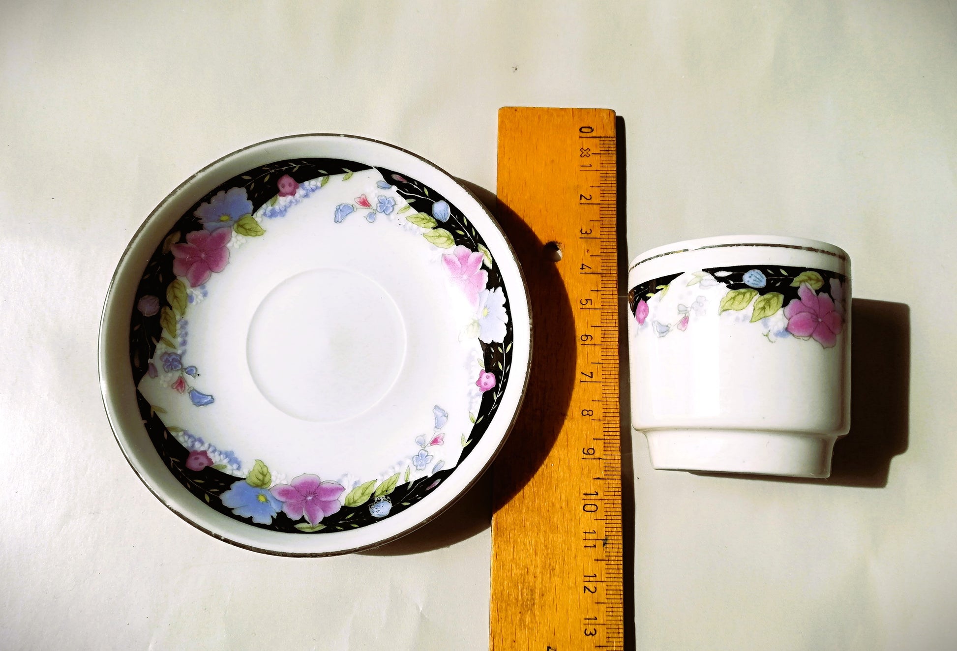 Sechsteiliges chinesisches Porzellan-Set mit bunten Blumenmotiven auf weißem Grund. Lineal zur Größenbestimmung.
