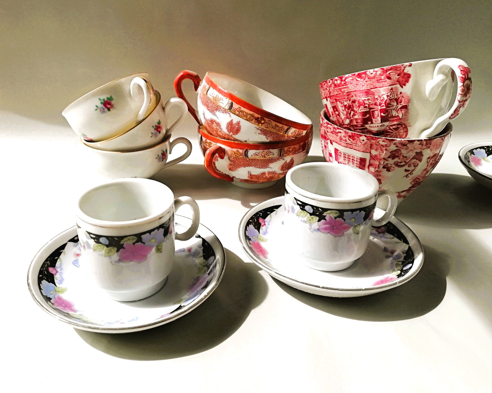 Sechsteiliges chinesisches Porzellan-Set mit bunten Blumenmotiven auf weißem Grund. 2 Tassen zusammen mit weiteren Tassen nterschiedlicher Farben.