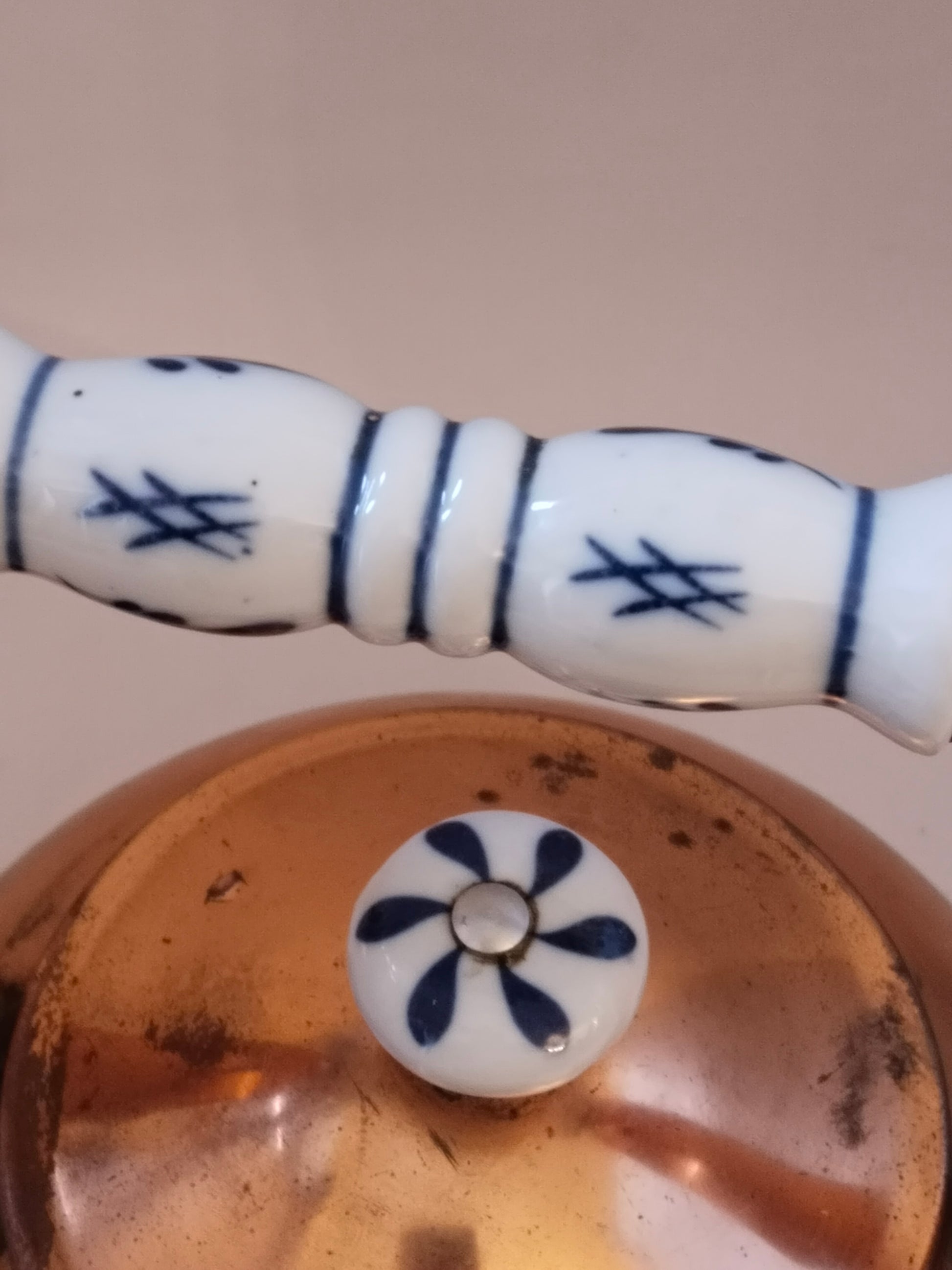 Detailaufnahme des Porzellangriffs mit blauem Blumenmuster auf weißem Grund.