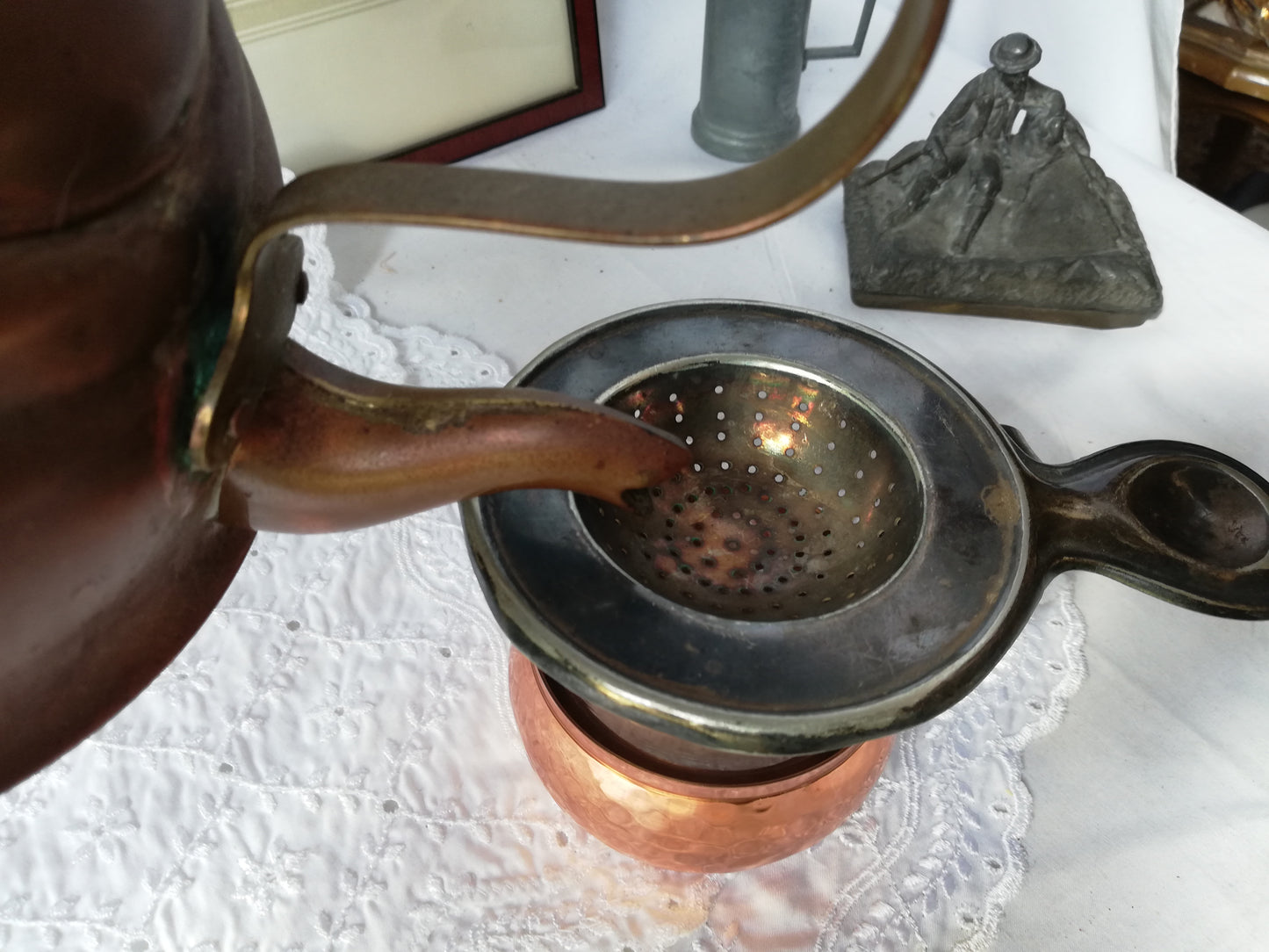 Antikes Teesieb von Moritz Hacker aus versilbertem Metall mit dunkler Patina auf weißer Spitze. Praktische Anwendung