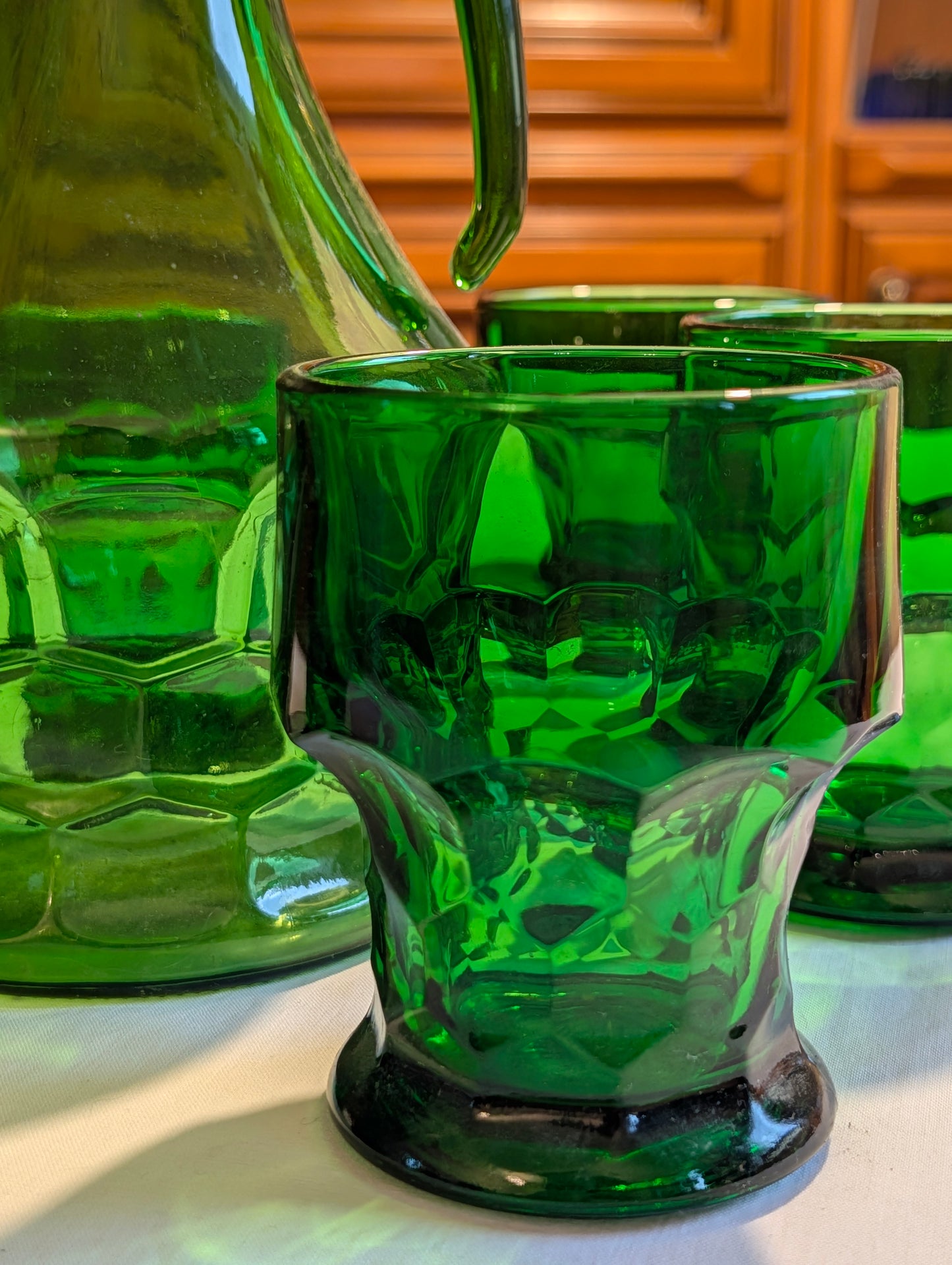 Grüne Karaffe mit Gläsern im warmen Lampenlicht, Mid-Century-Tafel
