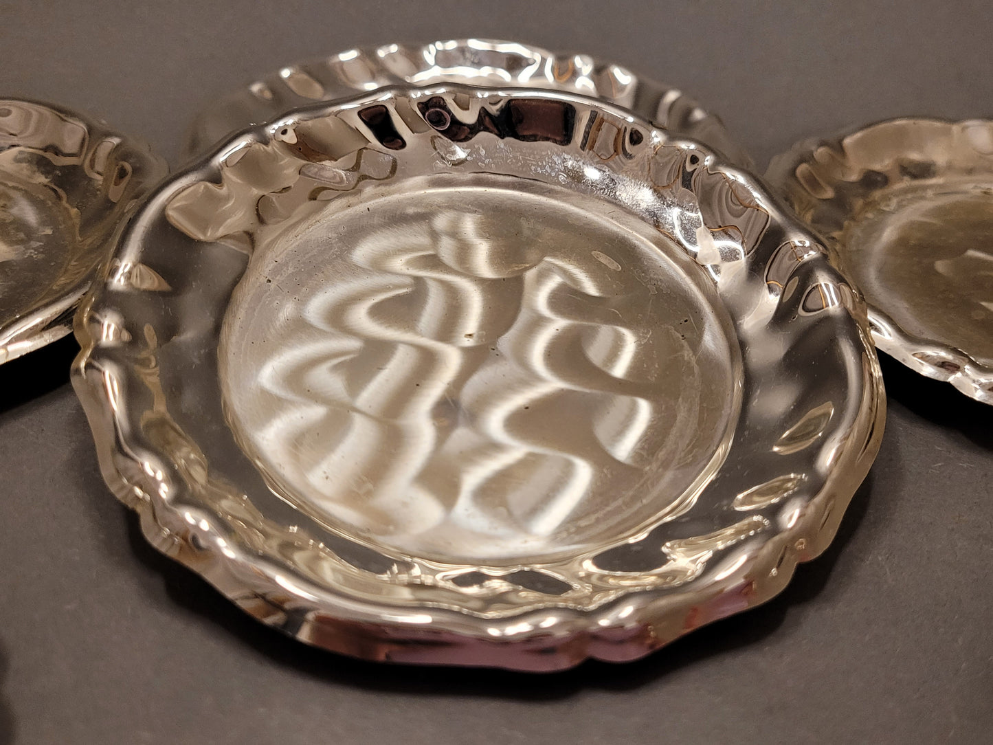 Nahaufnahme der versilberten Oberfläche mit klassischen Relief-Verzierungen.