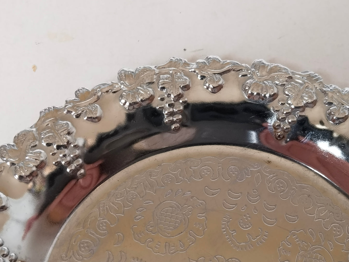 Detailaufnahme Weintrauben-Reliefrand – Trauben, Blätter, Ranken gepresst, versilbertes Metall, Vintage Getränkeuntersetzer