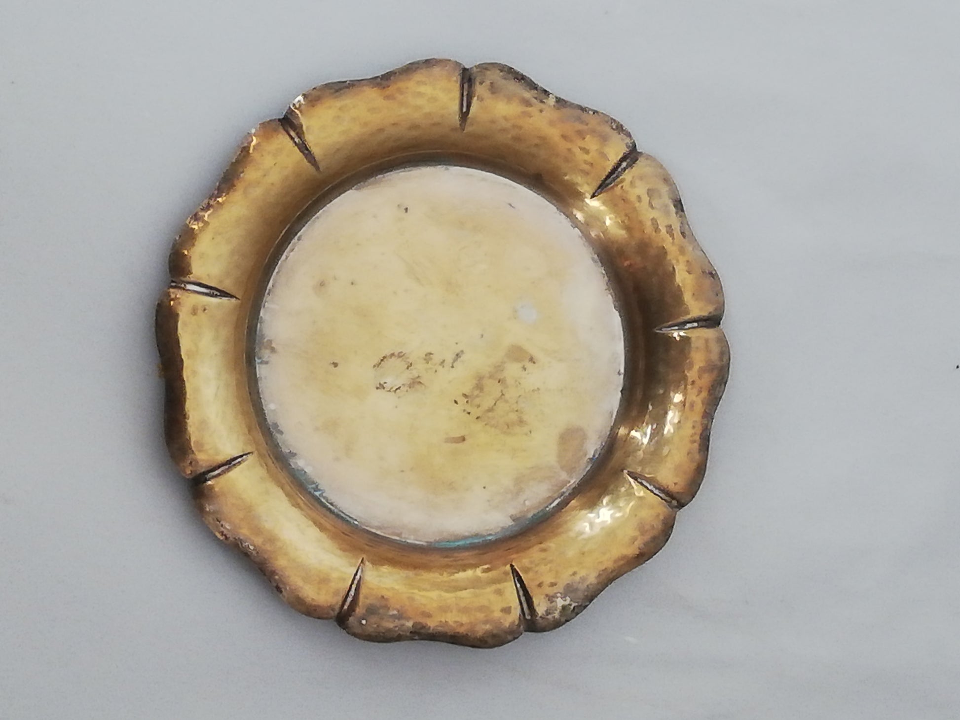 Nahaufnahme eines goldenen Untersetzers mit 7,5 cm Durchmesser und Maßband