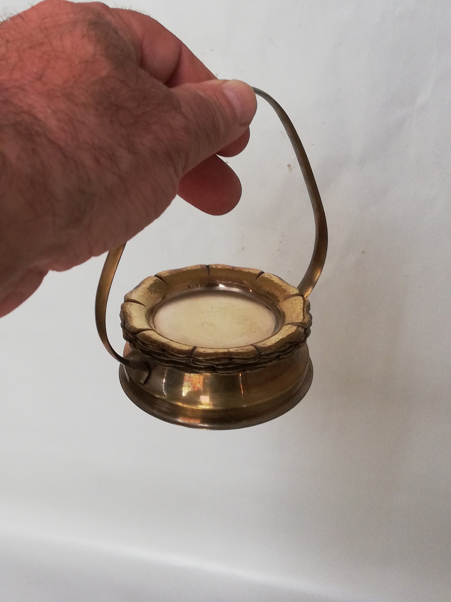 Traggestell mit 6 goldfarbenen Untersetzern in einer Hand gehalten