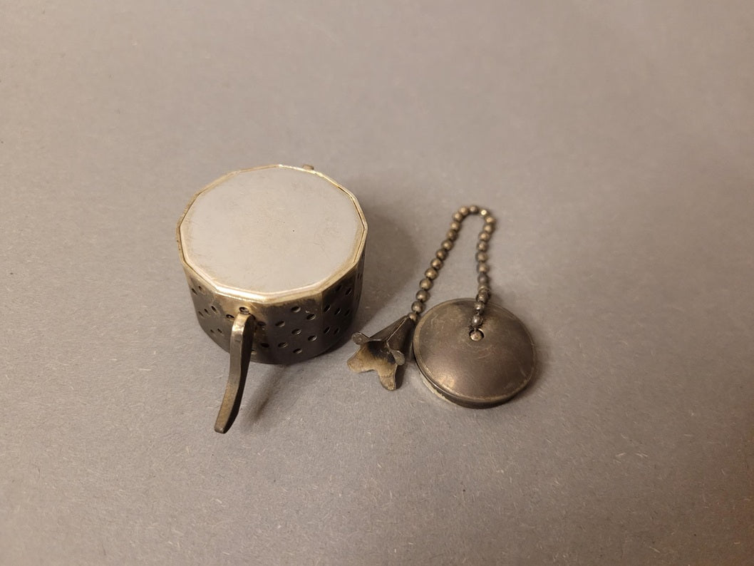 Unterseite des achteckigen Bodens der Miniatur-Teekanne aus Metall.