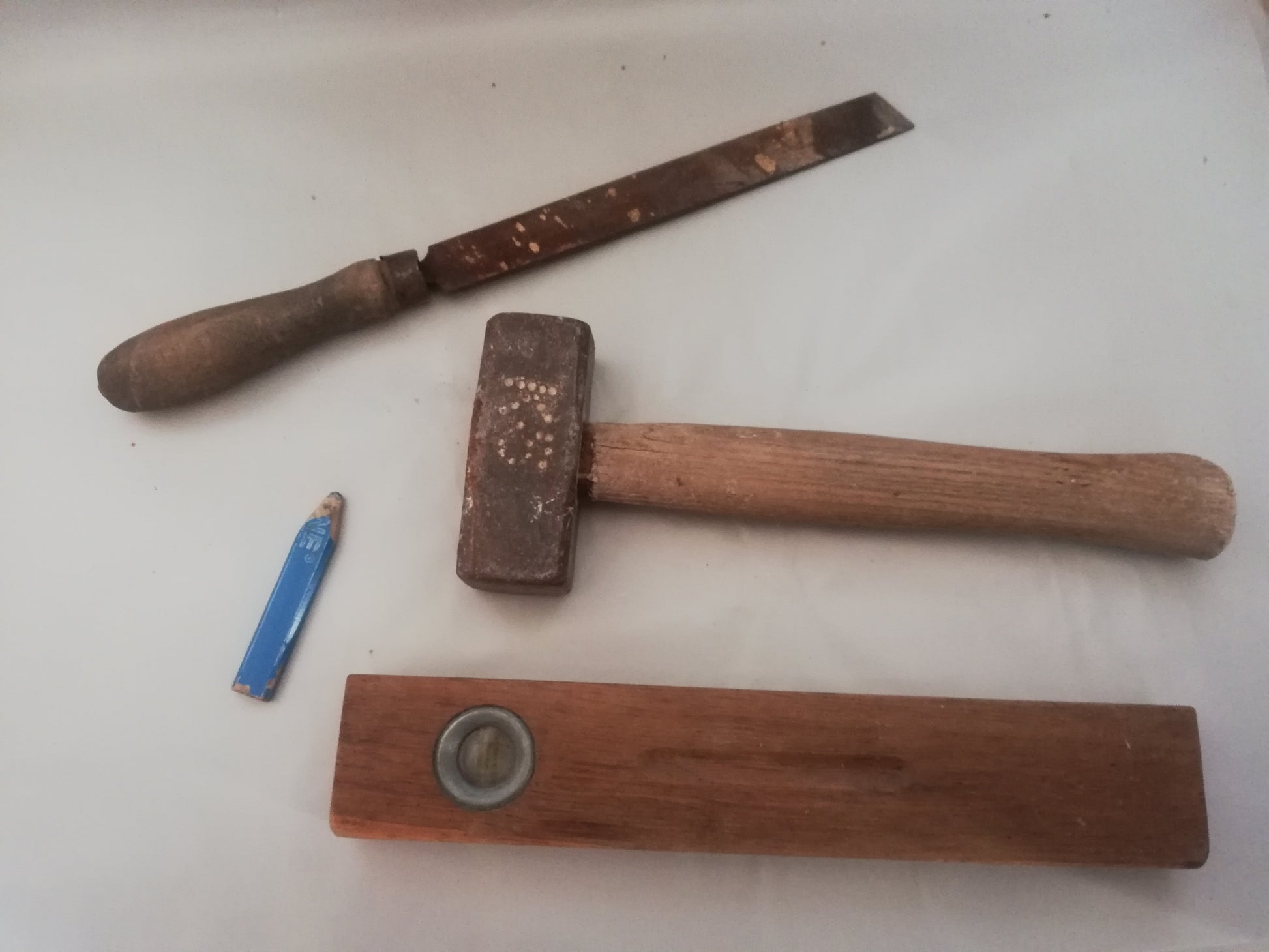 Vintage Wasserwaage 1950er Jahre Werkzeug mit altem Hammer und mit alter Feile und Bleistift.