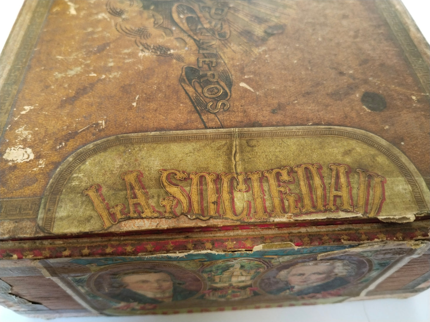 Detail des Markenetiketts La Sociedad an der Deckelecke mit sichtbarem Riss und Altersspuren
