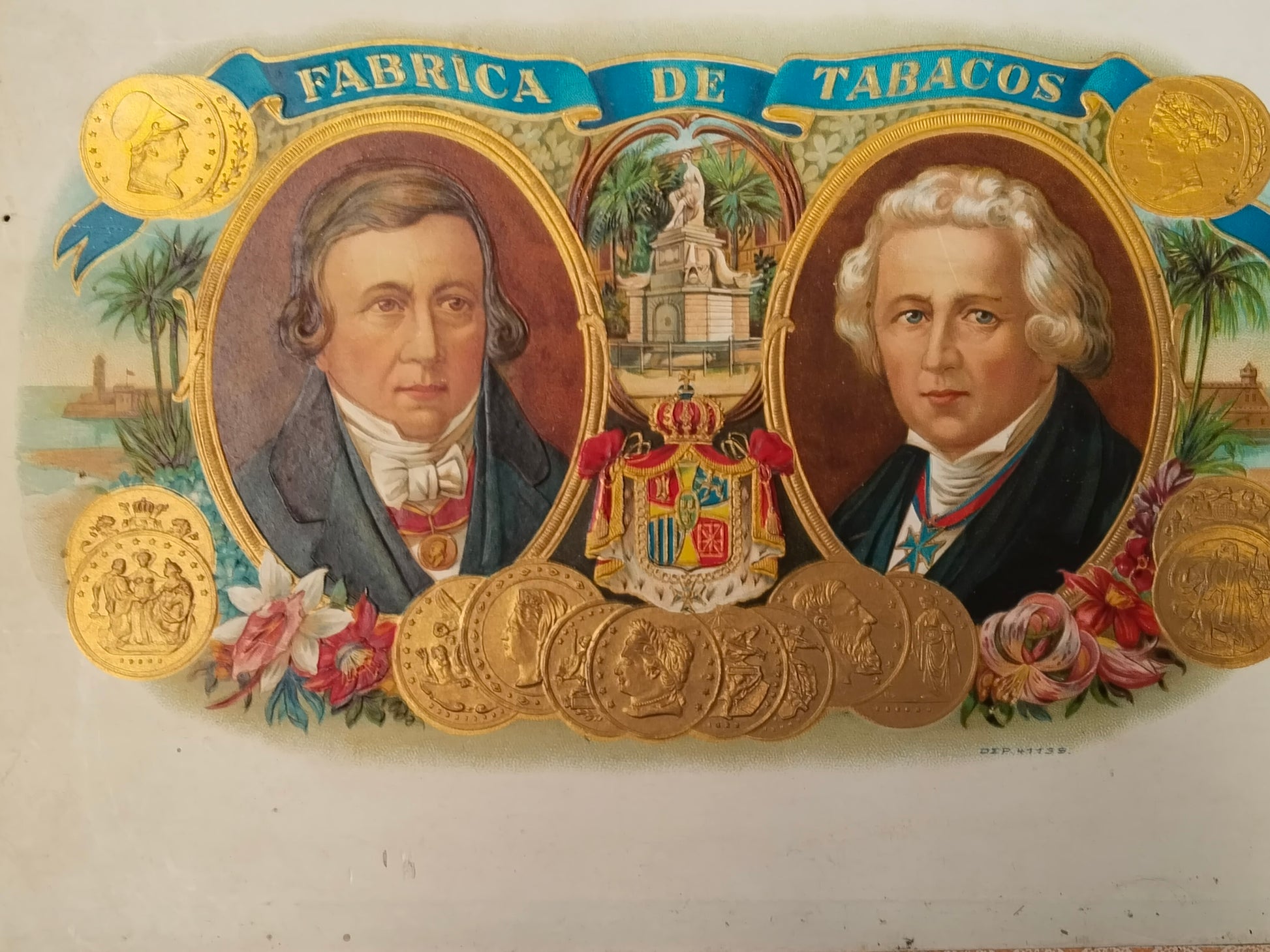 Nahaufnahme der farbfrischen Chromolithografie im Deckelinneren: Fabrica de Tabacos, zwei Porträts, Palmen und Goldmedaillen
