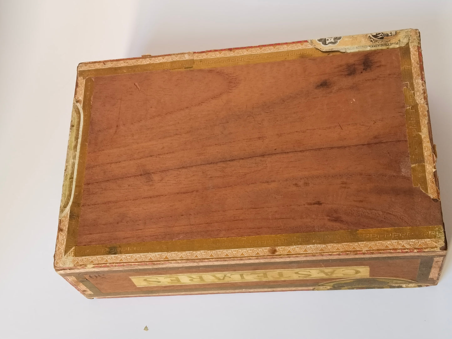 Unterseite der antiken Zigarrenkiste, unbehandeltes Holz mit goldener Randbordüre
