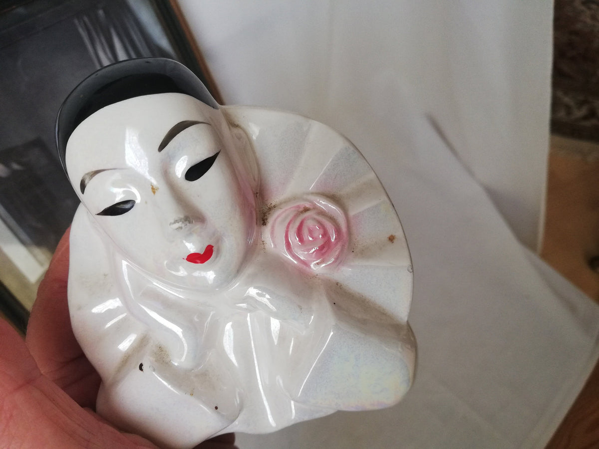 Pierrot-Figur neben weiteren Sammlerstücken in der Vitrine