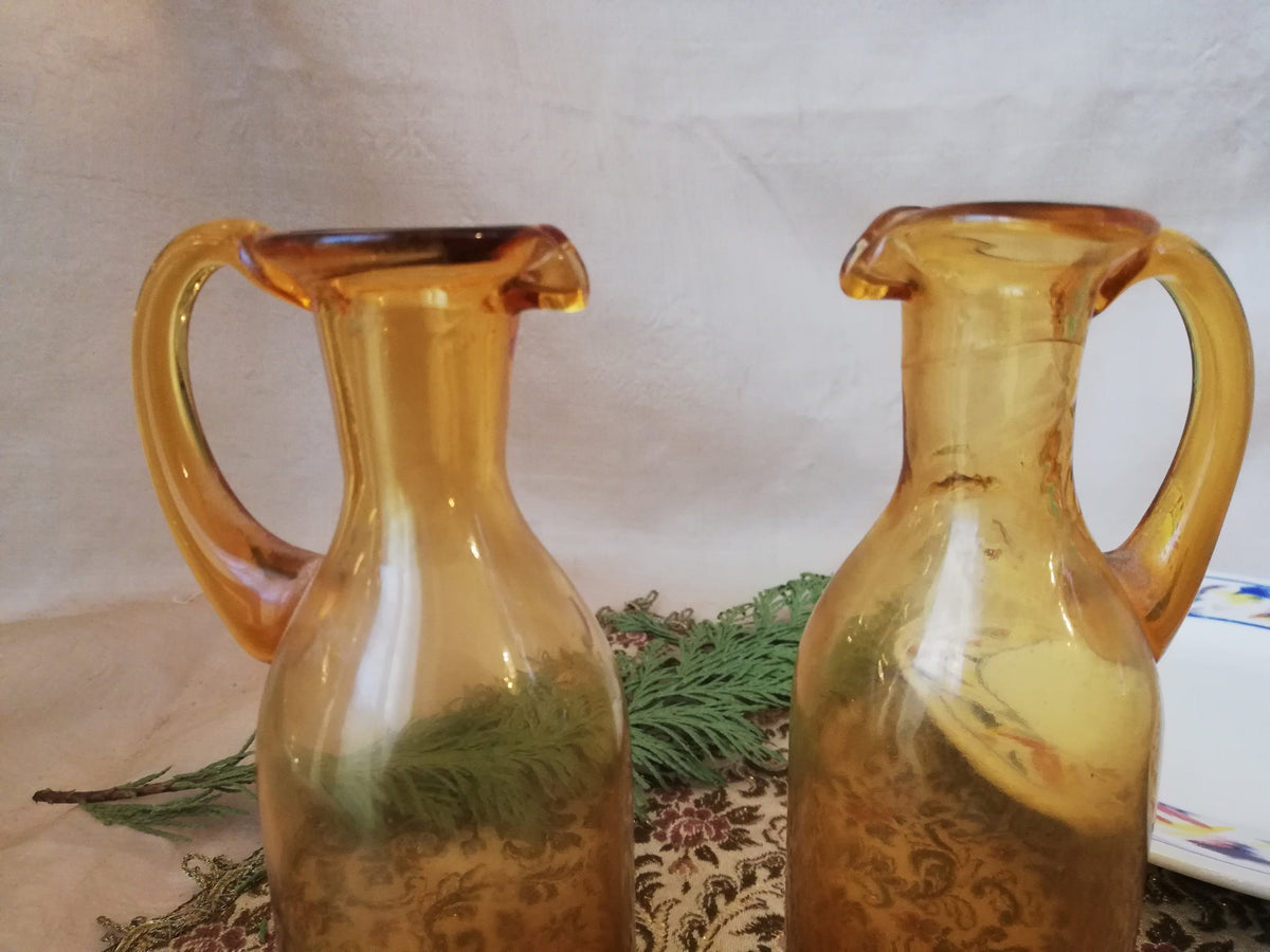 Two amber condiment bottles for oil and vinegar.