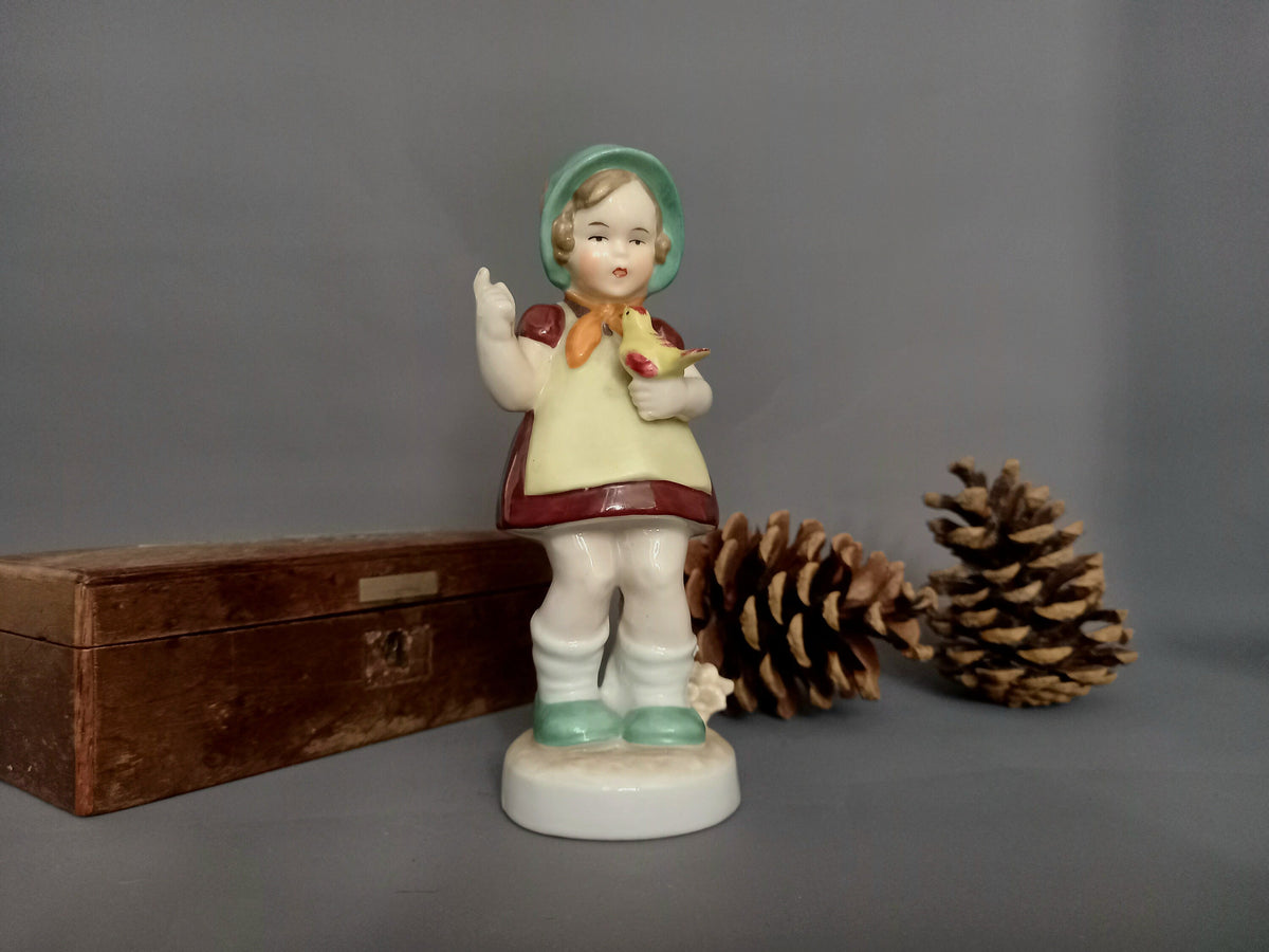 Porzellanfigur Mädchen mit Haube, Kleid und Vogel in der Hand – Gesamtansicht, Vintage Deutschland 1960er
