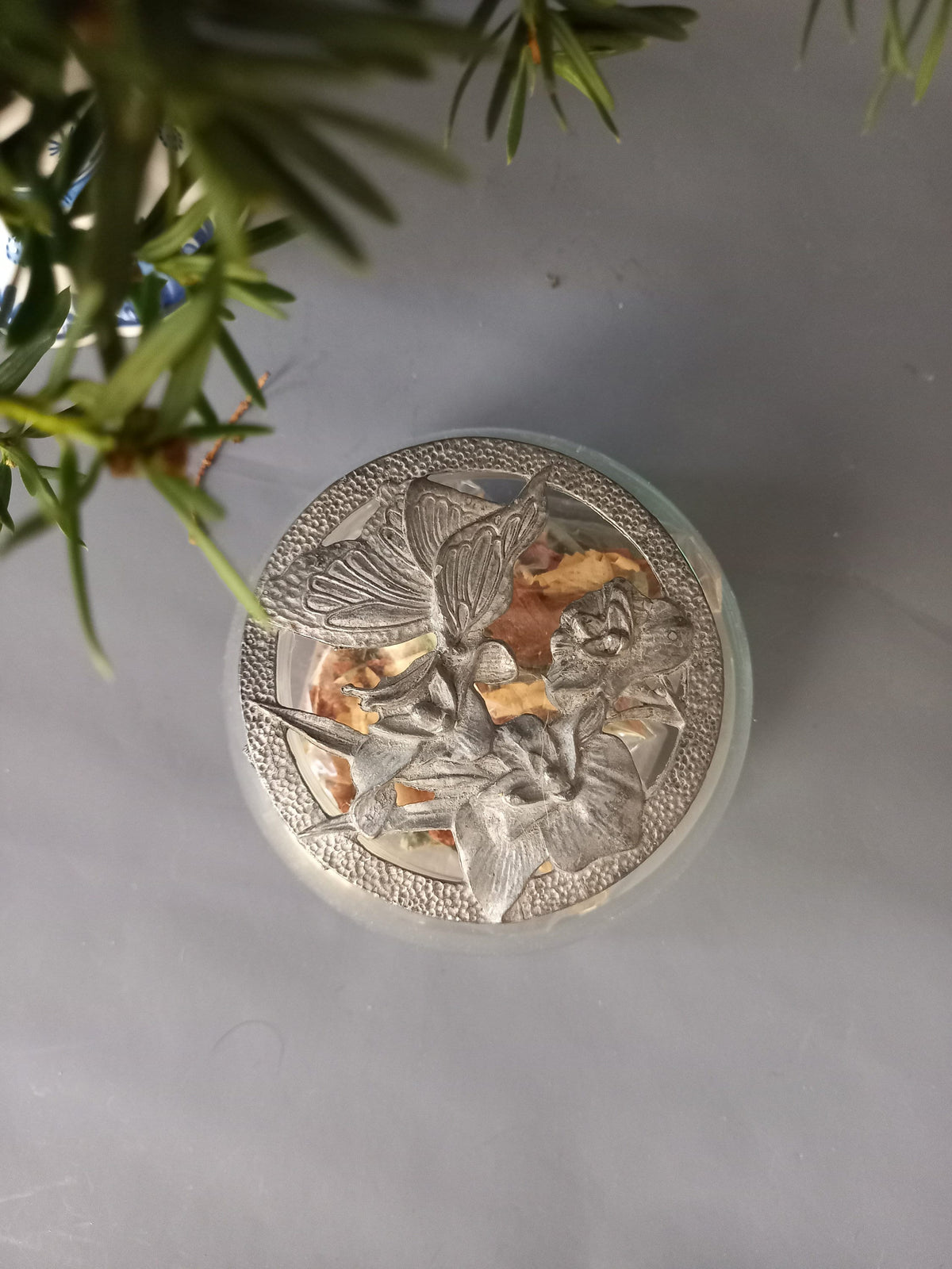 Schmetterling und Blüten auf dem Zinkdeckel im Detail