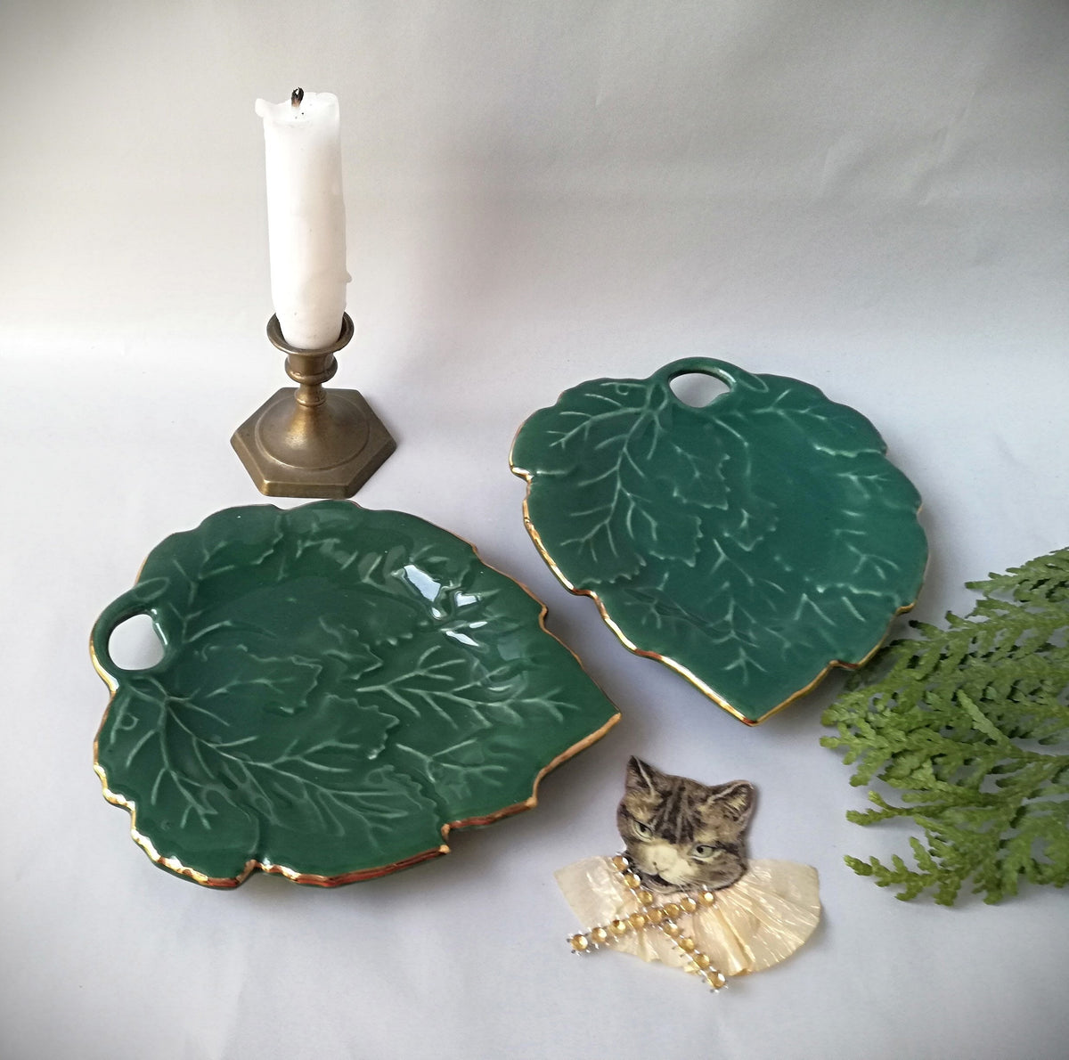 Stylish vintage coaster in the shape of a green vine leaf with gold trim