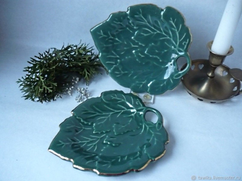 Stylish vintage coaster in the shape of a green vine leaf with gold trim