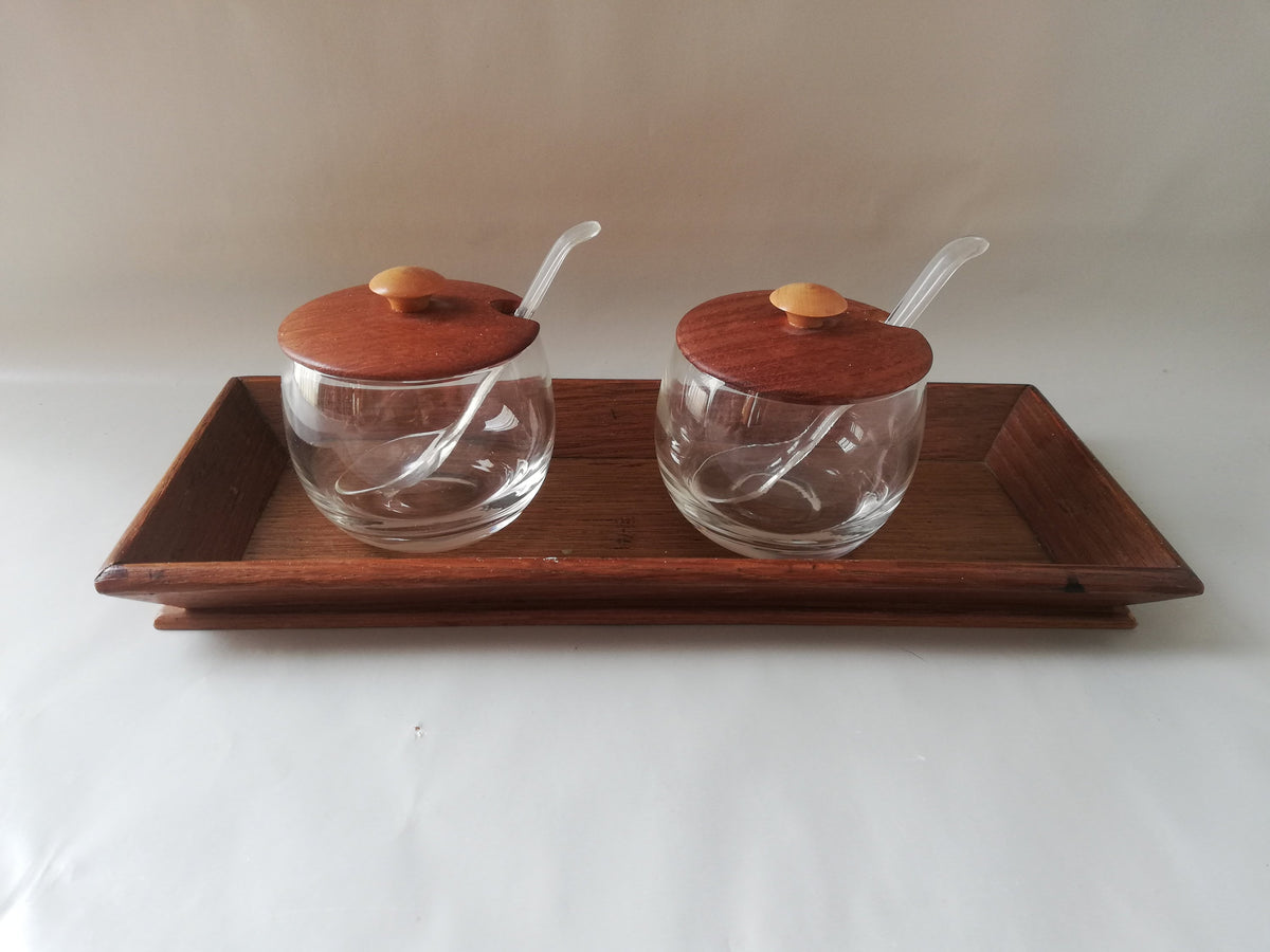 Glass jars with wooden lids and spoons for serving side dishes. Serving dishes for side dishes such as jam, ketchup, horseradish or caviar.