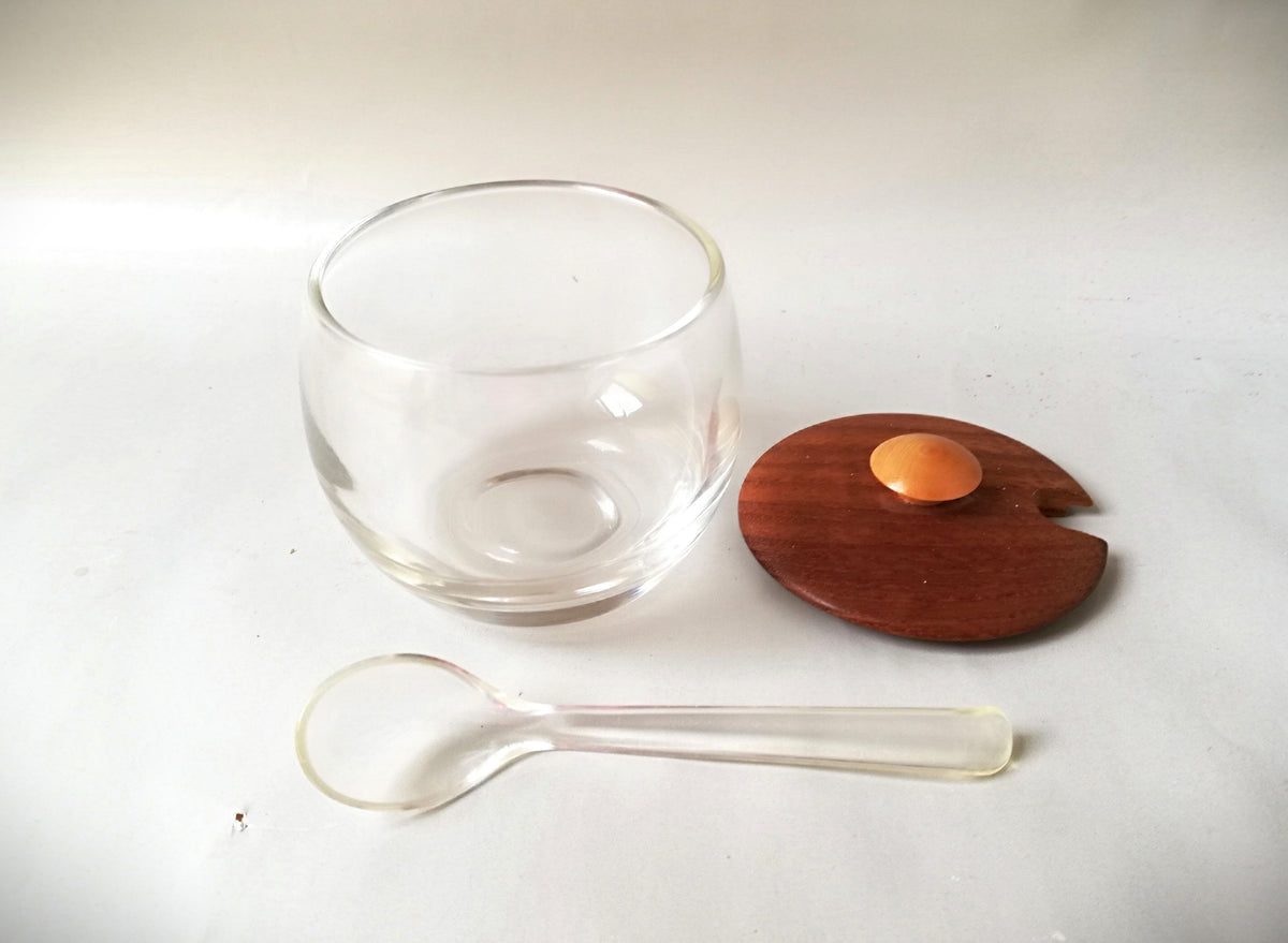 Glass jars with wooden lids and spoons for serving side dishes. Serving dishes for side dishes such as jam, ketchup, horseradish or caviar.