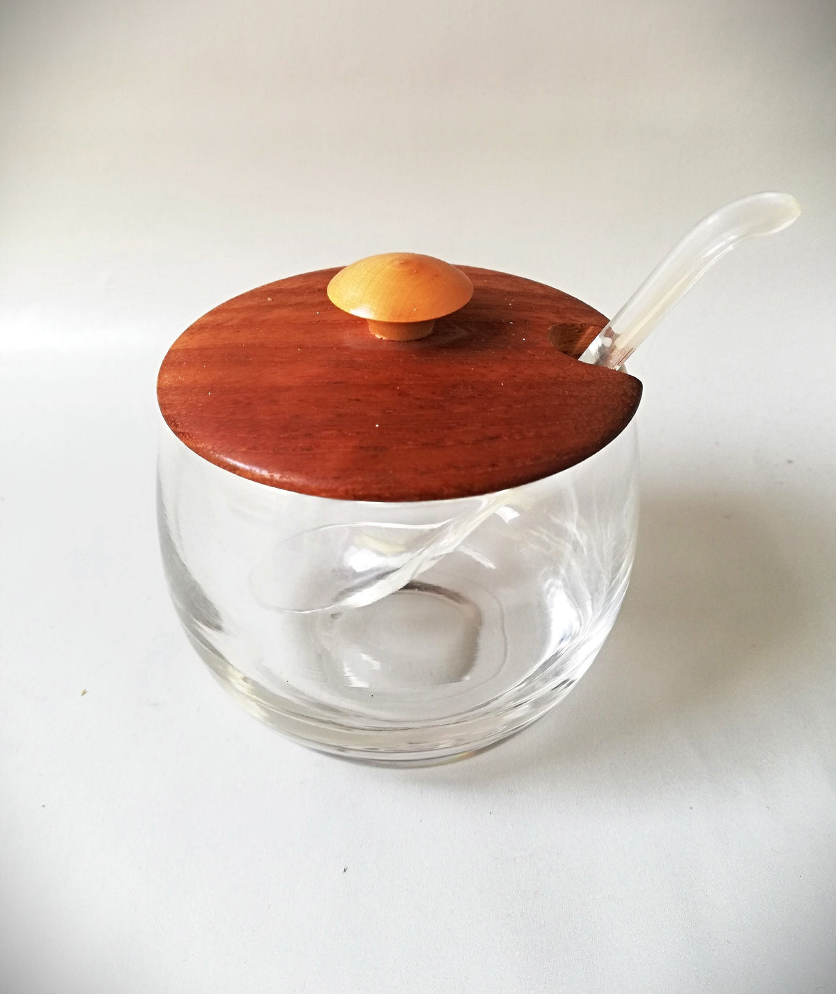 Glass jars with wooden lids and spoons for serving side dishes. Serving dishes for side dishes such as jam, ketchup, horseradish or caviar.