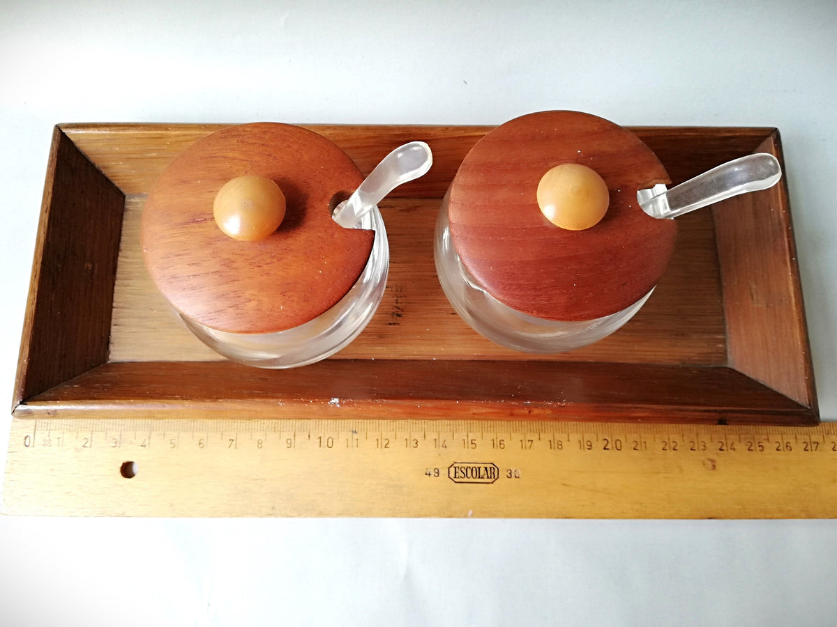 Glass jars with wooden lids and spoons for serving side dishes. Serving dishes for side dishes such as jam, ketchup, horseradish or caviar.