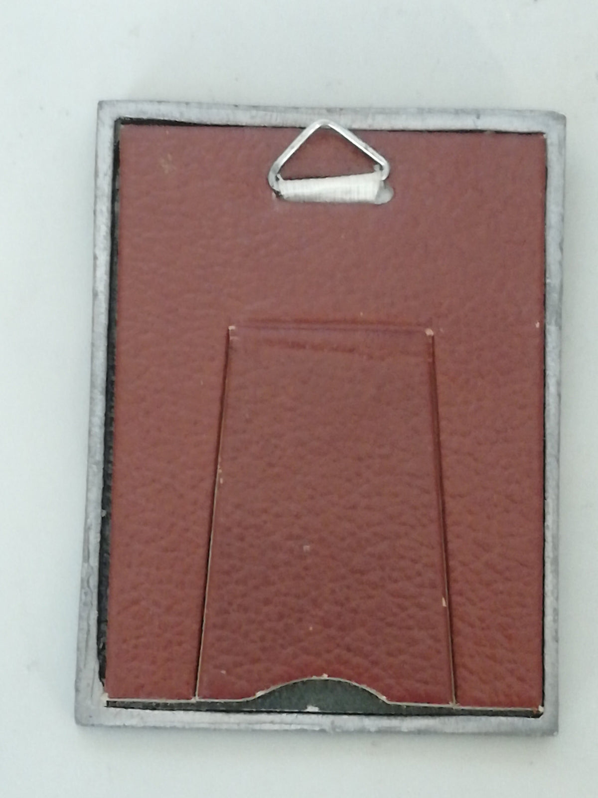 Vintage Madonna and Child on red velvet. Miniature icon with zinc frame and Madonna made of zinc.