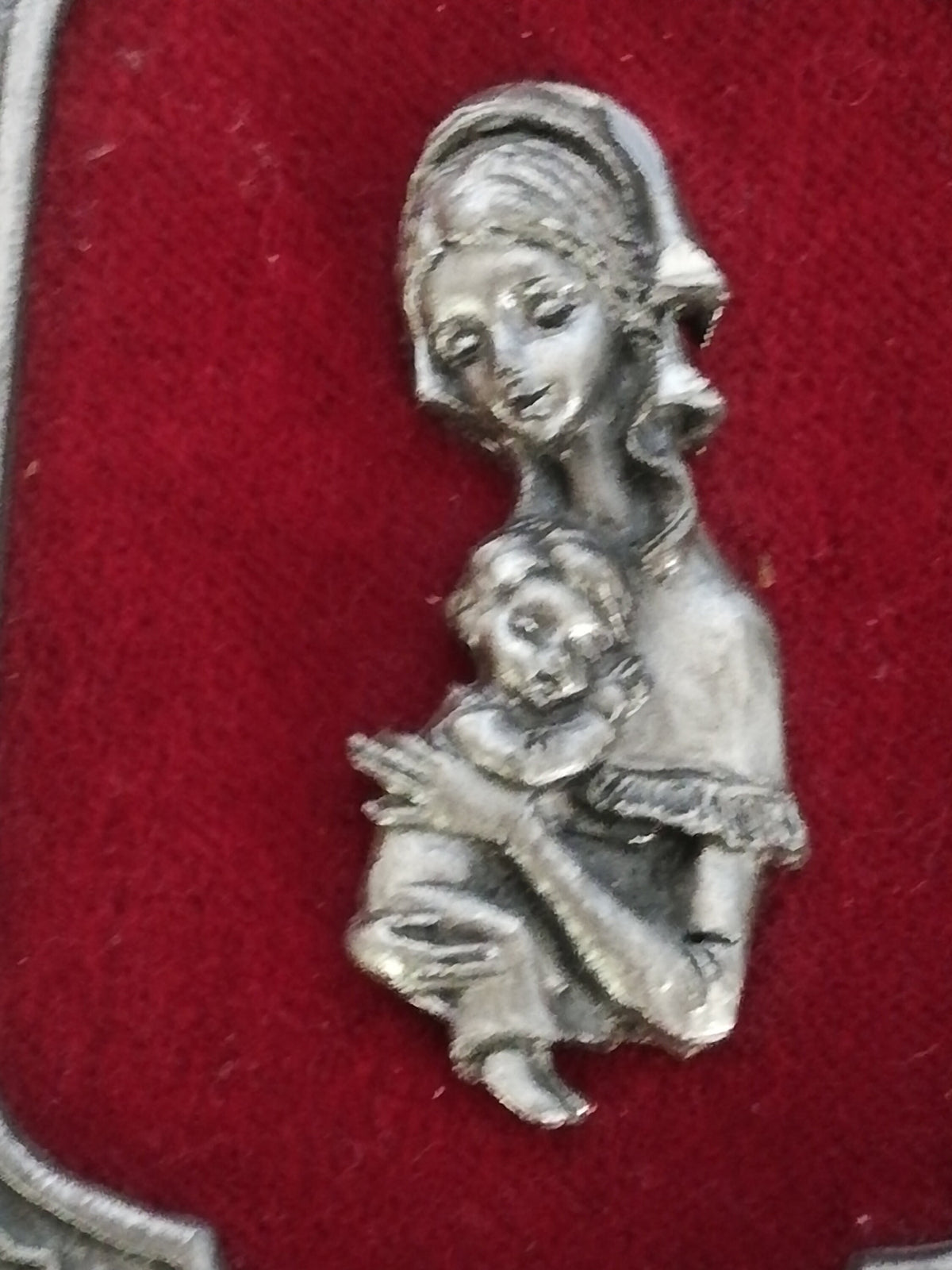 Vintage Madonna and Child on red velvet. Miniature icon with zinc frame and Madonna made of zinc.