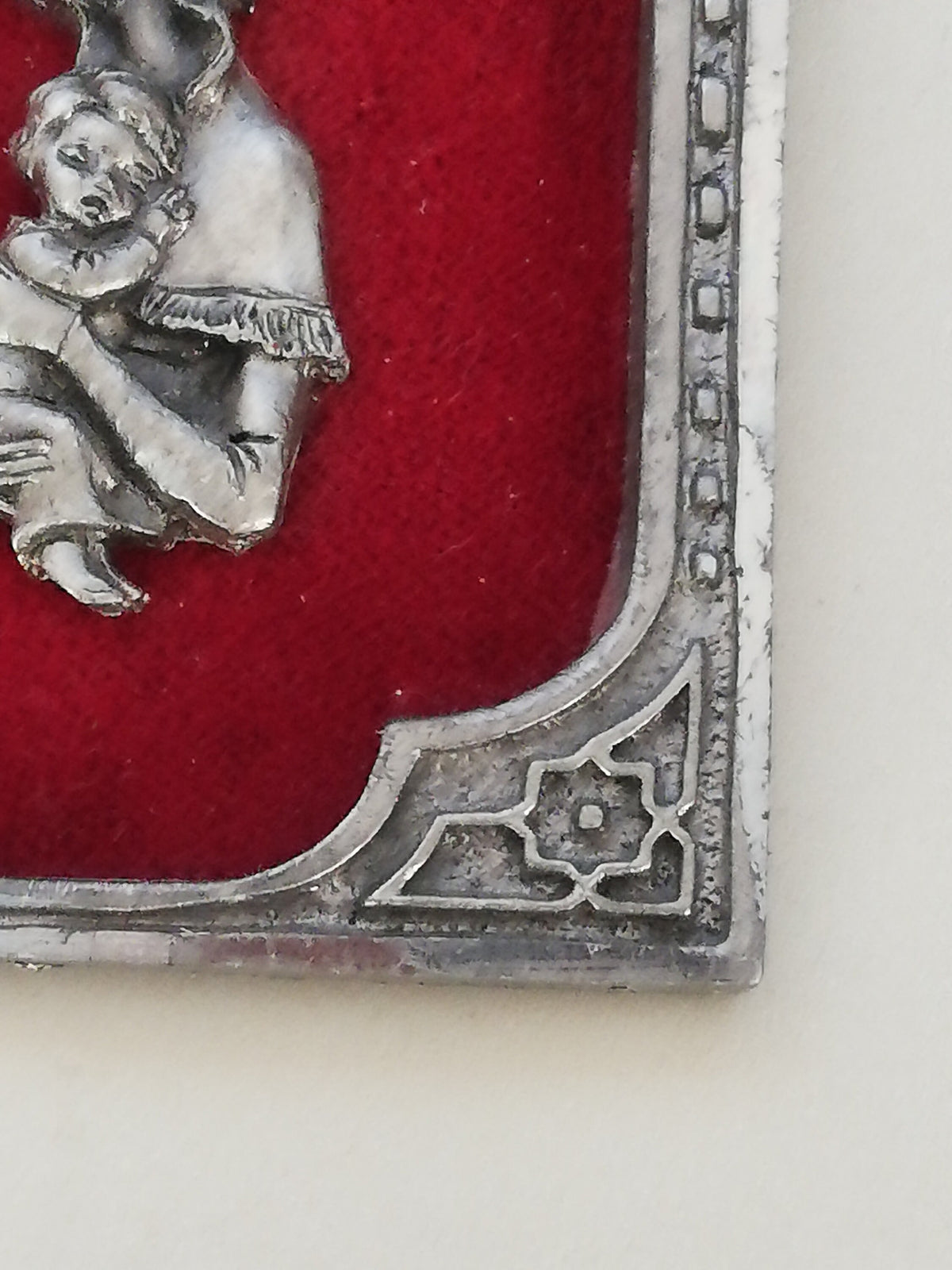 Vintage Madonna and Child on red velvet. Miniature icon with zinc frame and Madonna made of zinc.