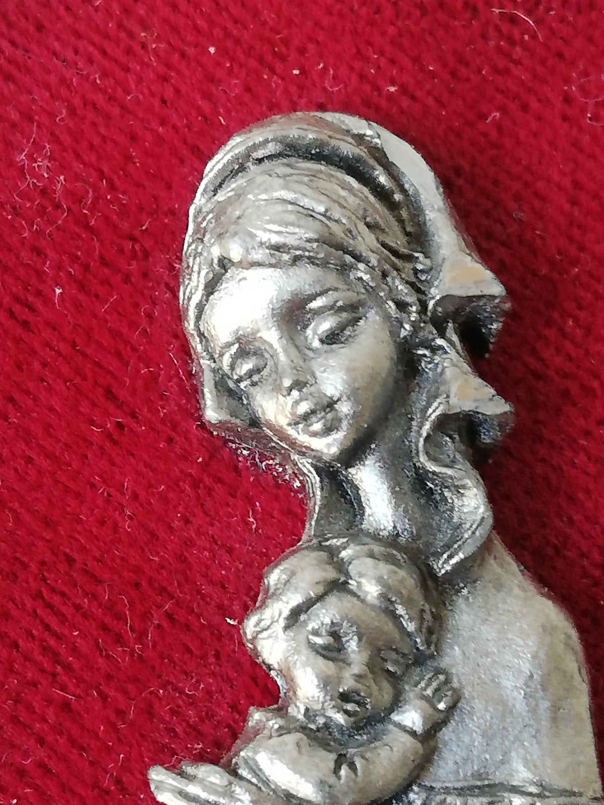 Vintage Madonna and Child on red velvet. Miniature icon with zinc frame and Madonna made of zinc.
