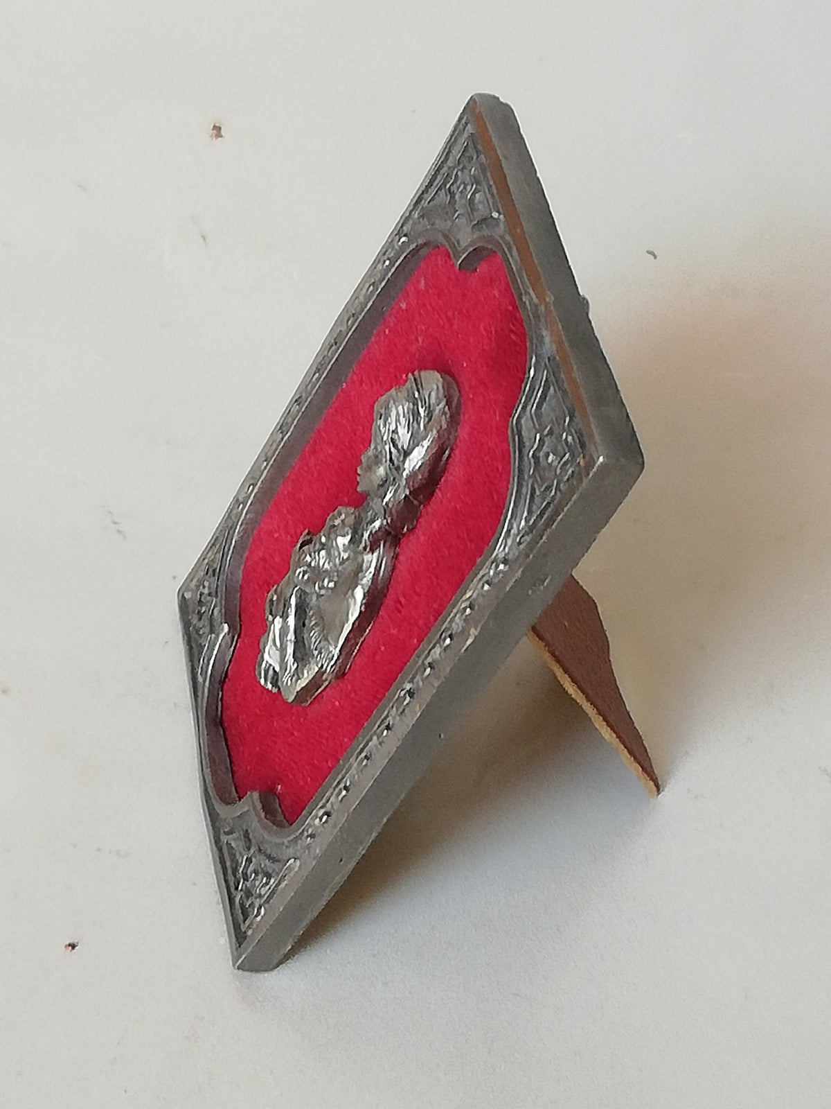 Vintage Madonna and Child on red velvet. Miniature icon with zinc frame and Madonna made of zinc.
