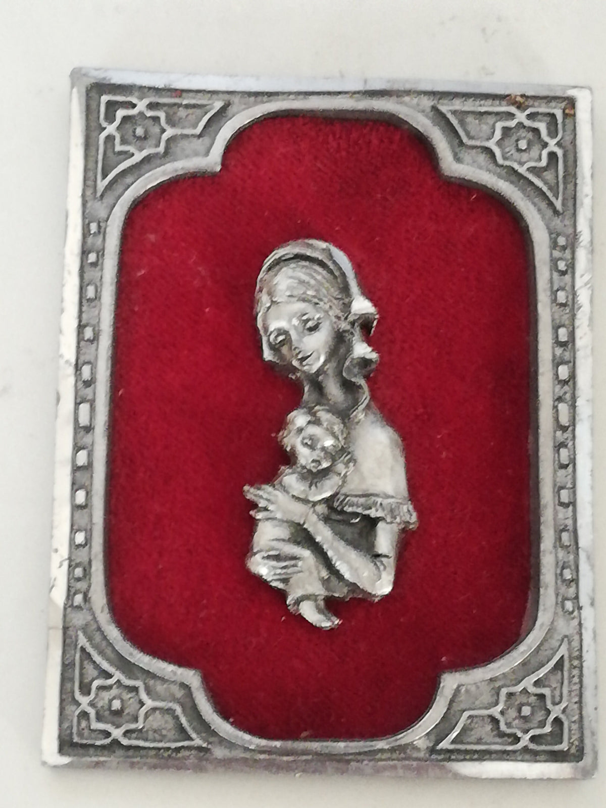 Vintage Madonna and Child on red velvet. Miniature icon with zinc frame and Madonna made of zinc.