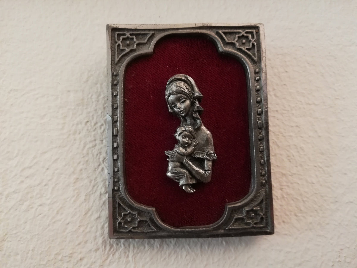 Vintage Madonna and Child on red velvet. Miniature icon with zinc frame and Madonna made of zinc.