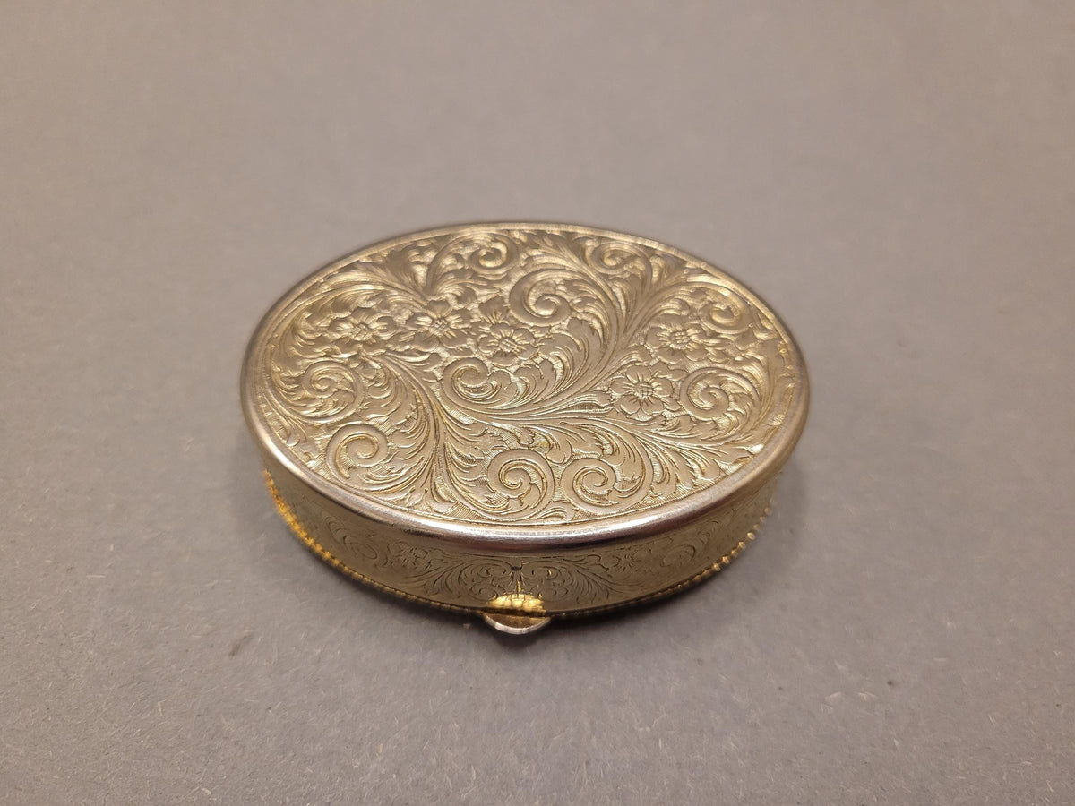 Goldfarbener Metallkörper mit Blumenornament
