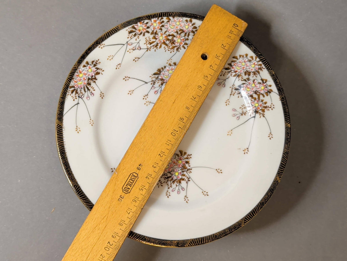 Einzelner Dessertteller mit Kirschblütenzweig zentriert