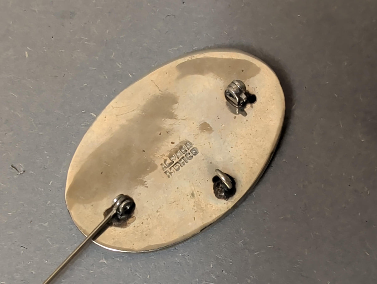 Brosche als Anhänger an einer Kette getragen