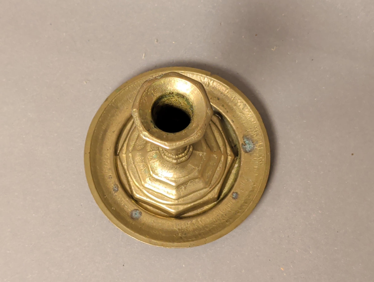 Leuchter mit brennender Kerze auf dunklem Untergrund