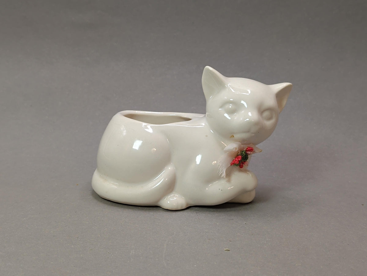 Vintage weiße Keramikkatze liegend mit Stoffschleife und Röschen, 1960er