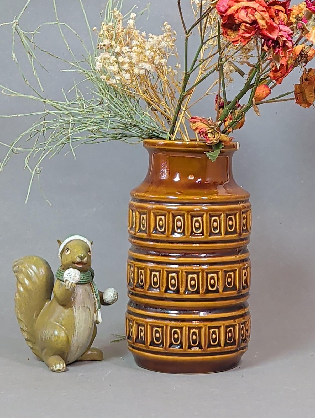 Vase mit Trockengräsern im Mid-Century-Regal