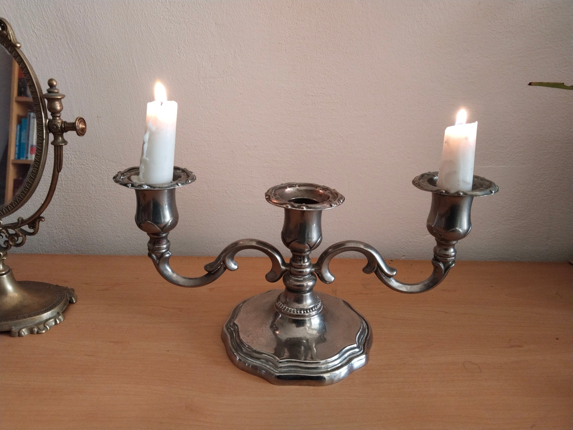 Dreiarmiger Kerzenhalter antik mit 2 brennenden Kerezen.