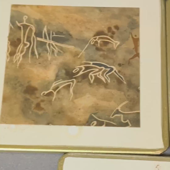 Fünf handgefertigte Vintage-Getränkeuntersetzer mit Felsmalerei-Motiven, cremeweißem Rand und Goldkante, Video.