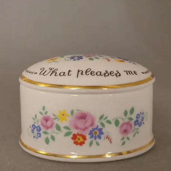 Ovale Pillendose aus weißem Bone China mit bunten Blumen. Video.