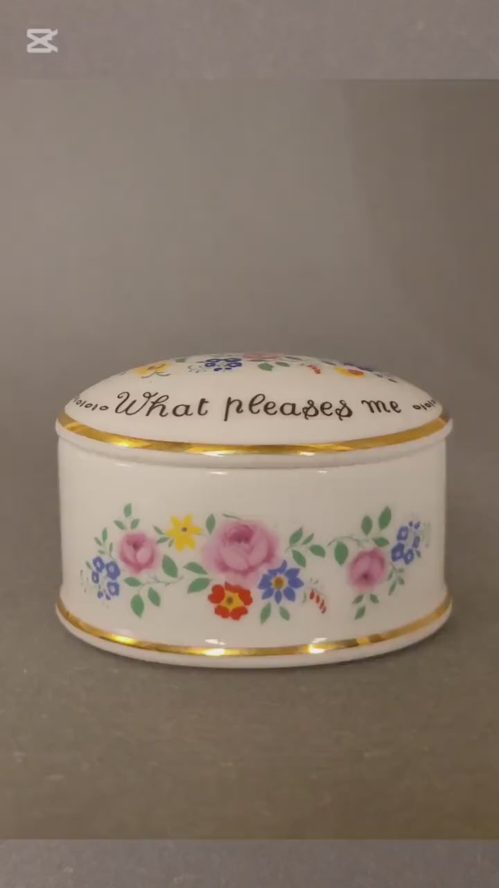 Ovale Pillendose aus weißem Bone China mit bunten Blumen. Video.