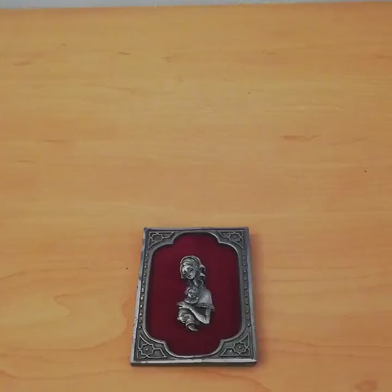 Vintage Madonna and Child on red velvet. Miniature icon with zinc frame and Madonna made of zinc.