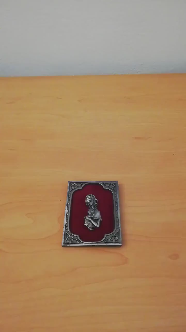 Vintage Madonna and Child on red velvet. Miniature icon with zinc frame and Madonna made of zinc.